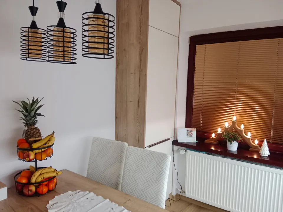 Biela vysoká skriňa s dubovým obkladom pri jedálenskom stole